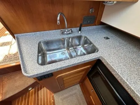 Slide: The Image of 2003 Hinckley Talaria 44 FB yacht kitchen with stainless steel sink and wooden cabinetry. - 16