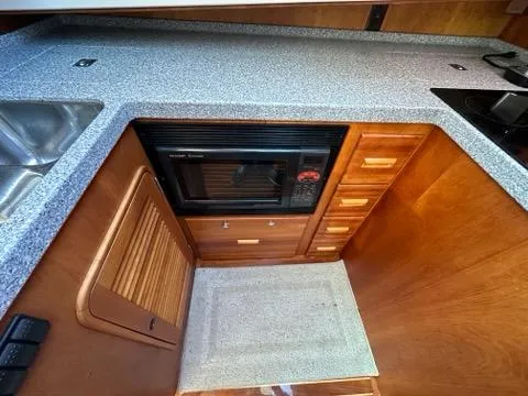Slide: The Image of 2003 Hinckley Talaria 44 FB yacht kitchen with wooden cabinets and modern appliances. - 17
