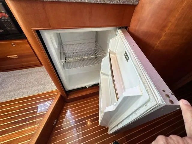 Slide: The Image of Open refrigerator in 2003 Hinckley Talaria 44 FB yacht interior, showcasing wooden flooring. - 19