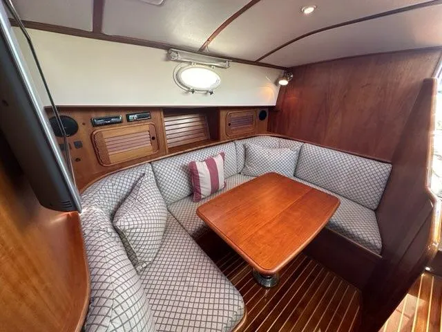 Slide: The Image of 2003 Hinckley Talaria 44 FB interior with wood table and cushioned seating. - 23