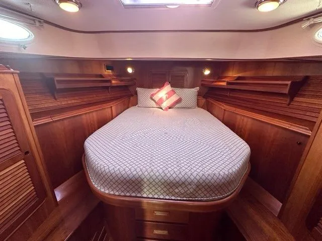 Slide: The Image of Luxurious 2003 Hinckley Talaria 44 FB cabin with elegant wood finish and cozy bedding. - 24