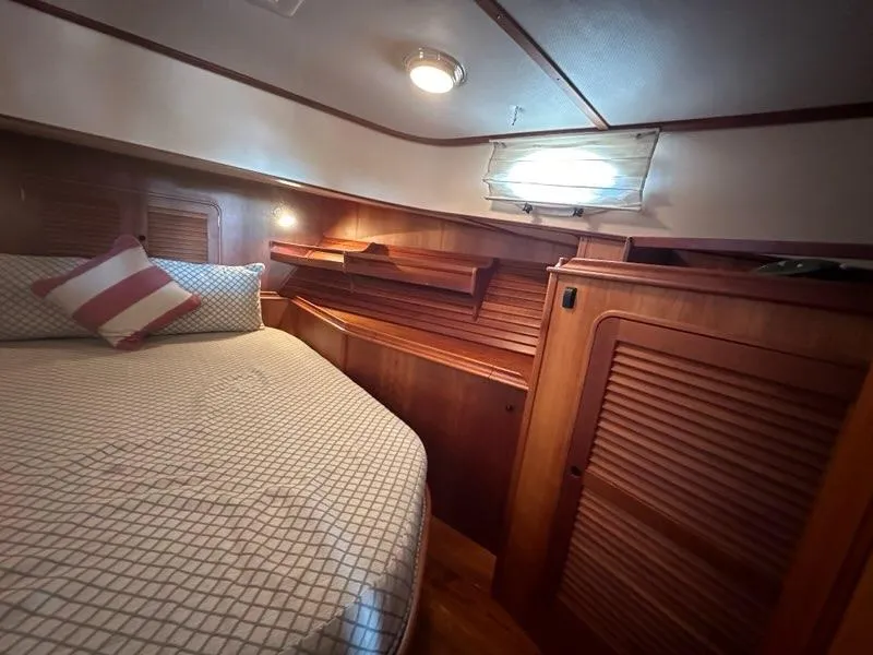 Slide: The Image of Cozy cabin interior of 2003 Hinckley Talaria 44 FB with wood paneling and bed. - 26