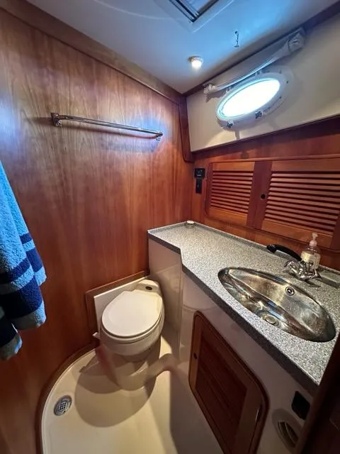 Slide: The Image of 2003 Hinckley Talaria 44 FB yacht bathroom with wood paneling and stainless steel sink. - 29