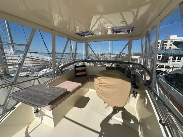 Slide: The Image of 2003 Hinckley Talaria 44 FB yacht interior with seating and helm, docked at marina. - 37