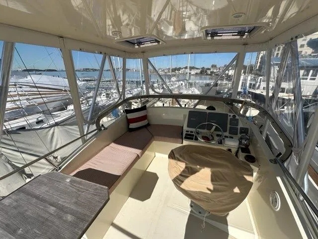 Slide: The Image of 2003 Hinckley Talaria 44 FB yacht interior with helm, seating, and marina view. - 38