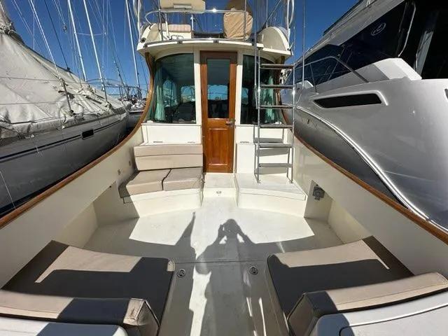 Slide: The Image of 2003 Hinckley Talaria 44 FB yacht deck with seating and ladder, docked between boats. - 46