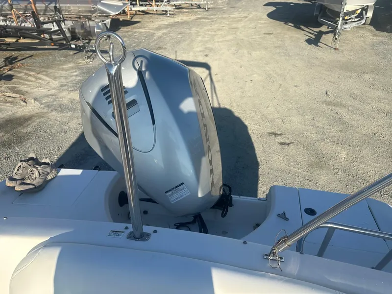 Slide: The Image of 2012 Godfrey Hurricane 237 boat with outboard motor in a sunny outdoor setting. - 14