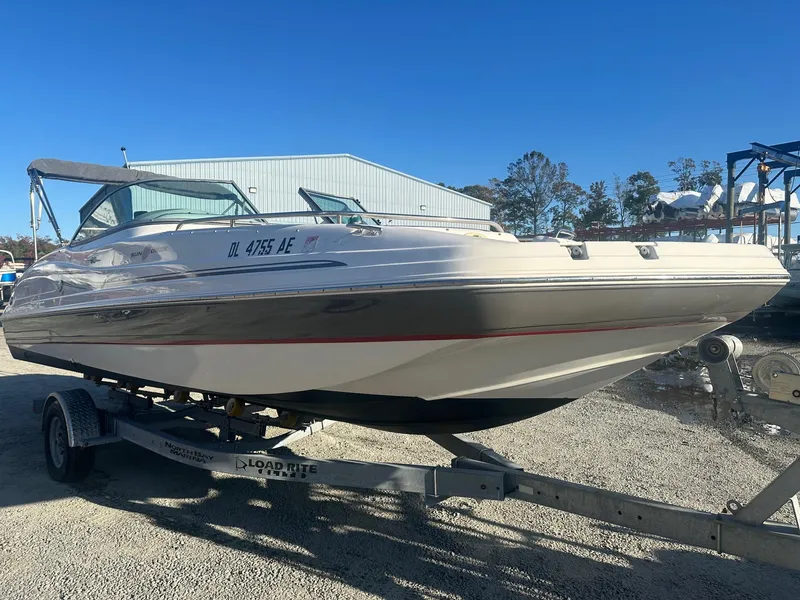 Slide: The Image of 2012 Godfrey Hurricane 237 boat on trailer, parked outdoors under clear blue sky. - 2