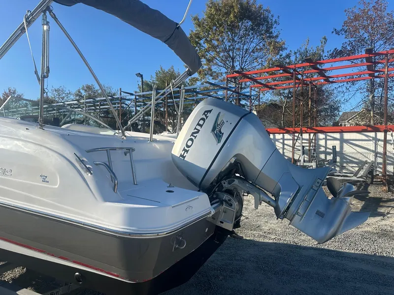 Slide: The Image of 2012 Godfrey Hurricane 237 boat with Honda outboard motor in a sunny outdoor setting. - 4