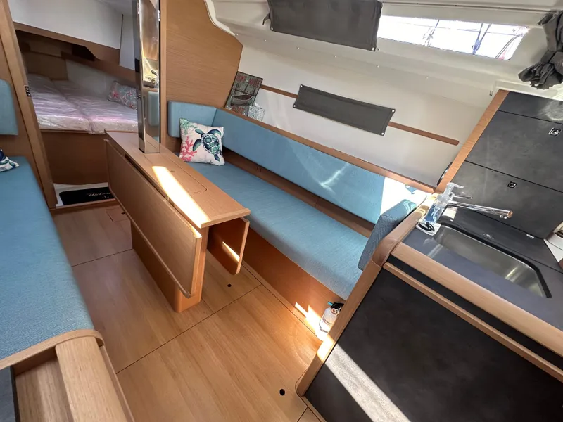 Slide: The Image of Interior of 2022 Jeanneau Sun Odyssey 349 sailboat with modern seating and compact kitchen. - 13
