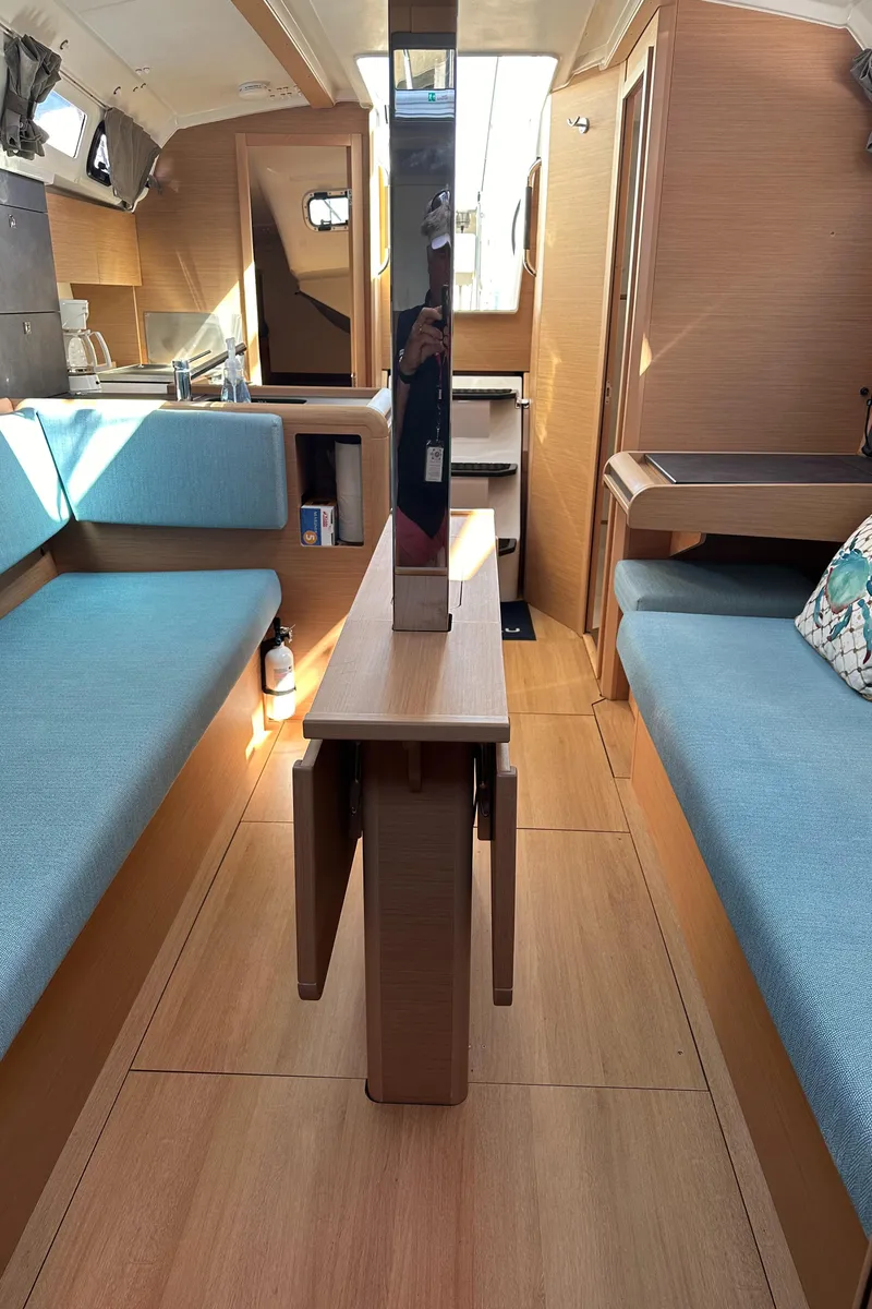 Slide: The Image of Interior of 2022 Jeanneau Sun Odyssey 349 sailboat with wooden finishes and blue seating. - 15