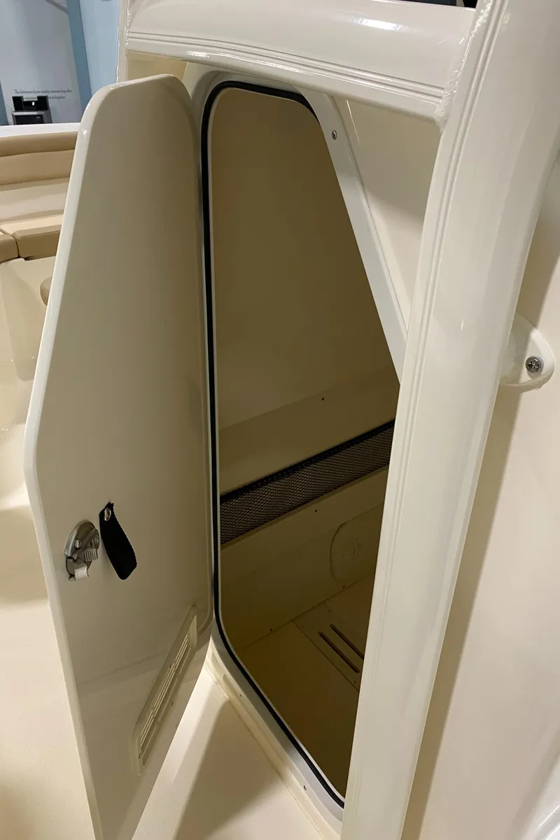 Slide: The Image of 2024 Scout 215 XSF boat storage compartment with open door. - 13