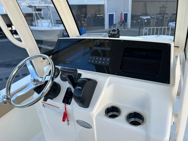Slide: The Image of 2024 Scout 215 XSF boat dashboard with steering wheel and controls. - 3