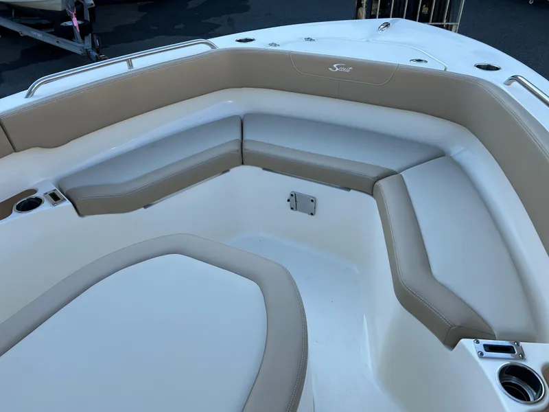 Slide: The Image of 2024 Scout 215 XSF boat interior with beige seating and cup holders. - 4