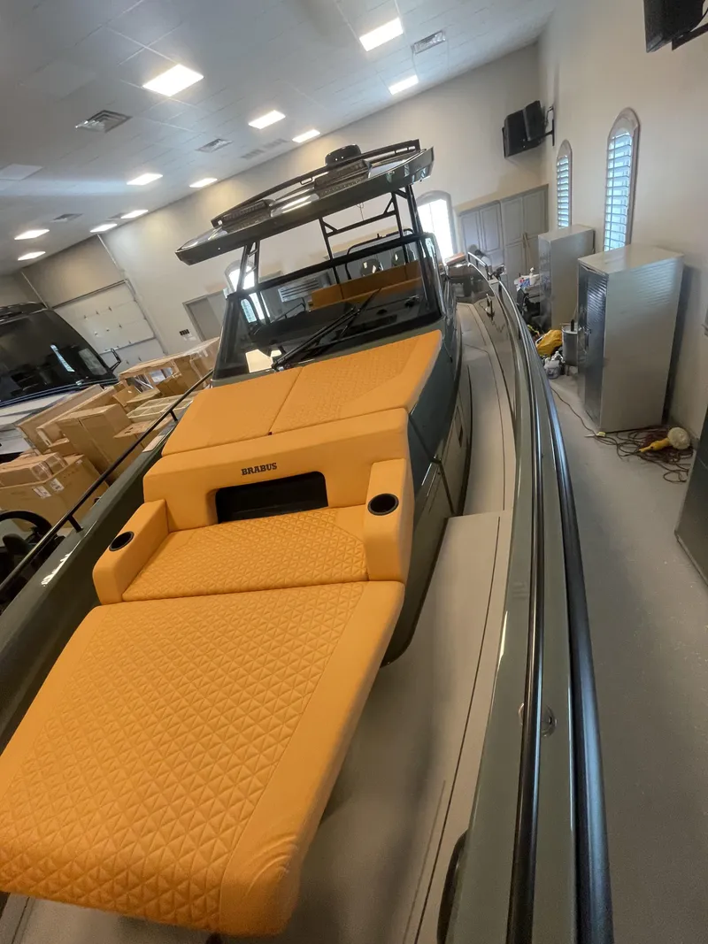 Slide: The Image of 2023 BRABUS Shadow 900 Stealth Green boat with orange seating in showroom. - 3