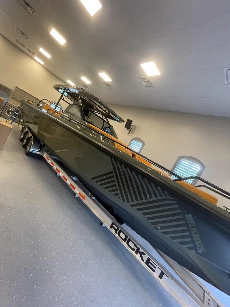Slide: The Image of 2023 BRABUS Shadow 900 Stealth Green boat on trailer indoors. - 5