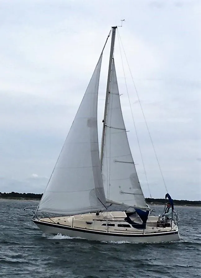 The Image of 1979 O'Day 28 sailboat navigating on open water under cloudy skies. - 0