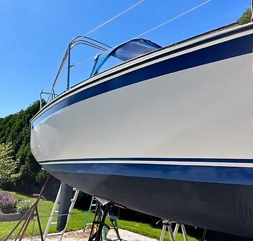 Slide: The Image of 1979 O'Day 28 sailboat on stands, blue stripe, sunny day. - 18