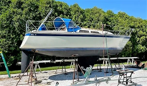 Slide: The Image of 1979 O'Day 28 sailboat on stands, surrounded by greenery, under a clear blue sky. - 22