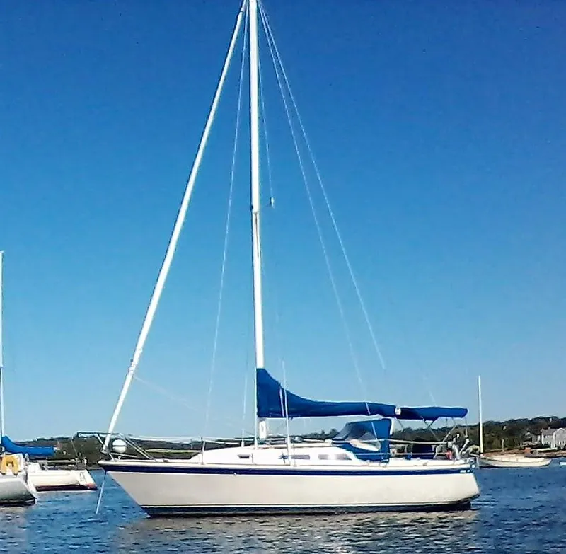 Slide: The Image of 1979 O'Day 28 sailboat with blue sail cover on calm water. - 24
