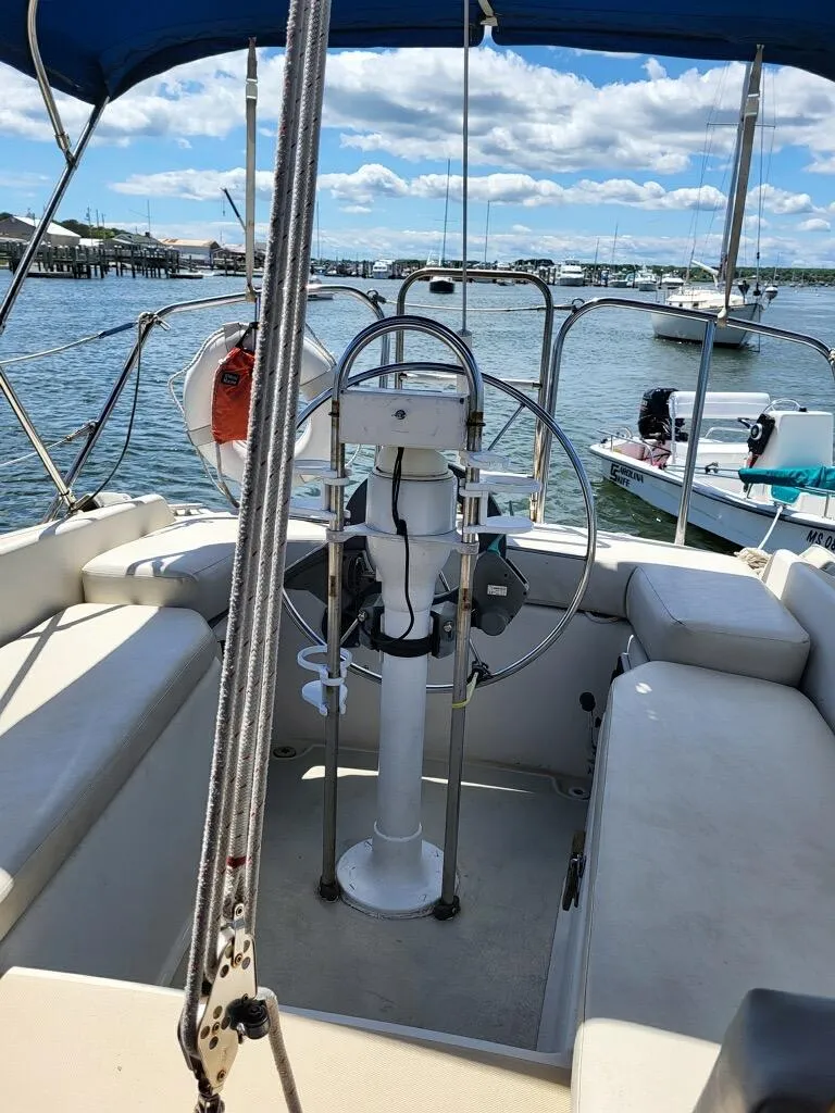 Slide: The Image of 1979 O'Day 28 sailboat cockpit with steering wheel, docked in a marina under blue skies. - 25