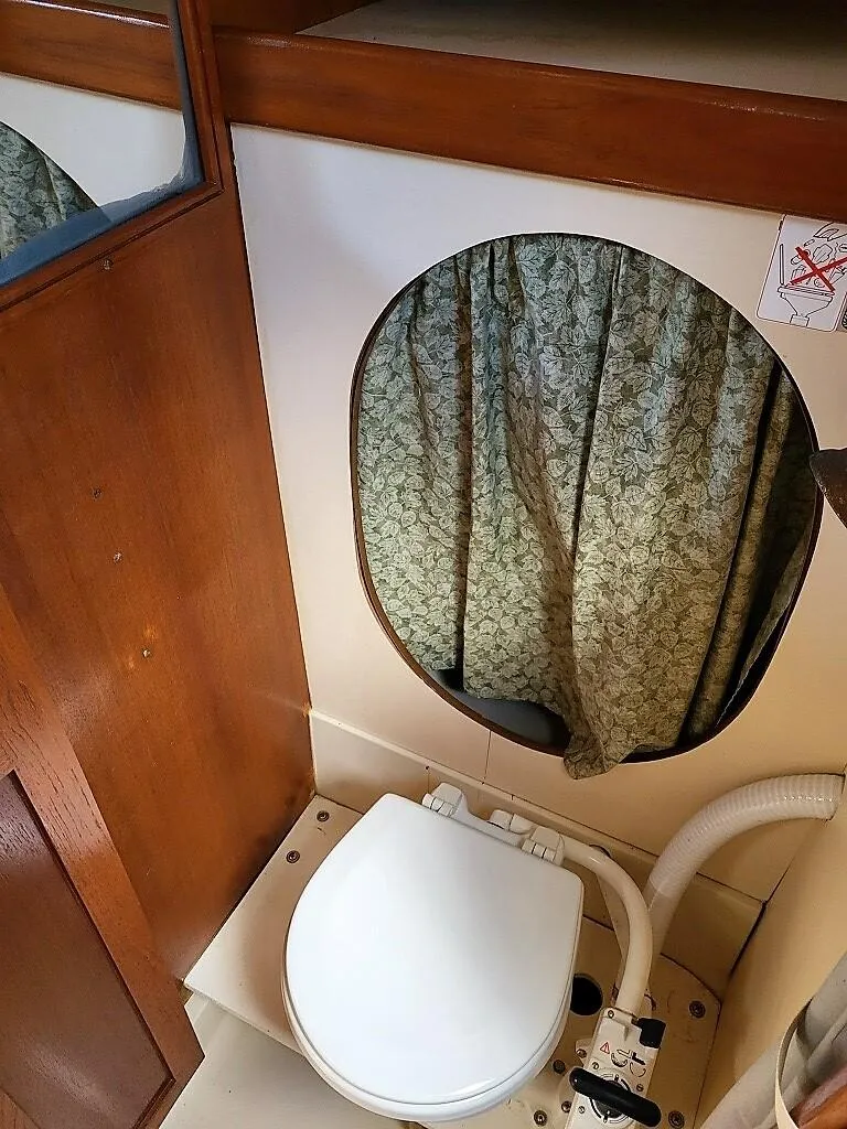 Slide: The Image of 1979 O'Day 28 sailboat bathroom with toilet and floral curtain. - 29