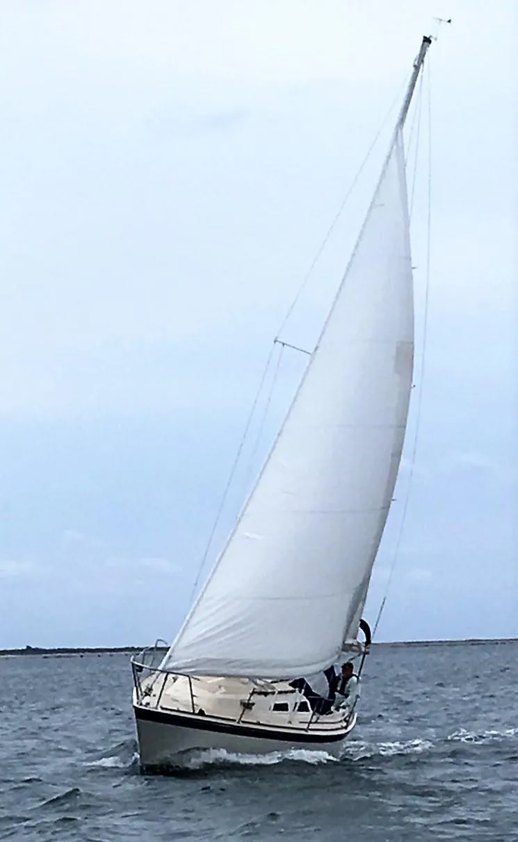 Slide: The Image of 1979 O'Day 28 sailboat navigating on open water under full sail. - 3
