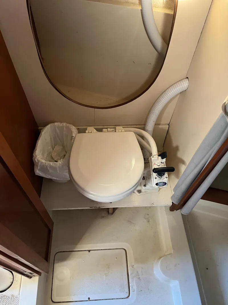Slide: The Image of 1979 O'Day 28 sailboat bathroom with toilet and waste bin. - 30
