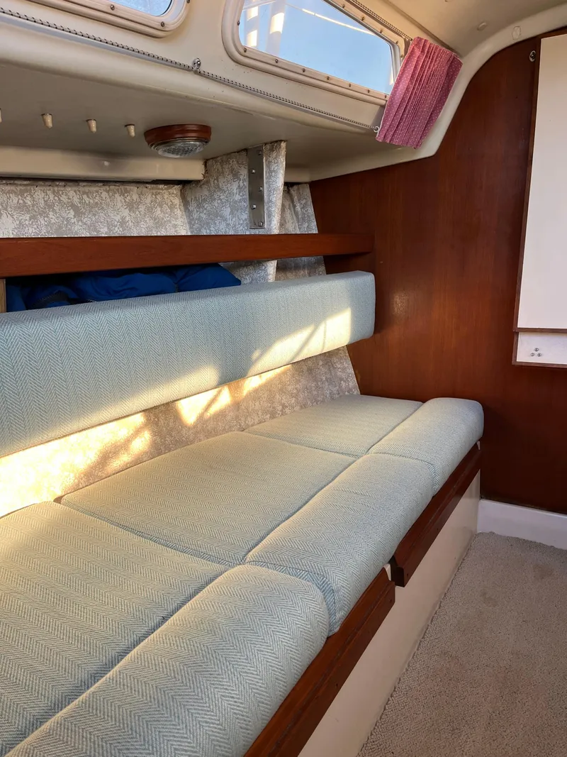 Slide: The Image of 1979 O'Day 28 sailboat interior with cushioned seating and wooden accents. - 35
