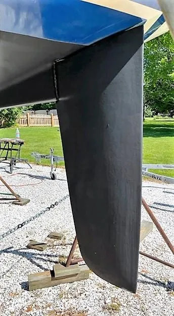 Slide: The Image of 1979 O'Day 28 sailboat keel on a trailer, outdoors in a sunny setting. - 6