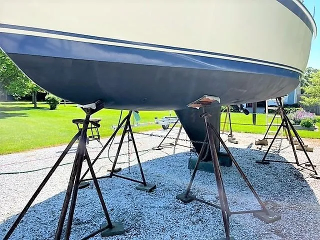 Slide: The Image of 1979 O'Day 28 sailboat on stands, displayed outdoors on gravel. - 9