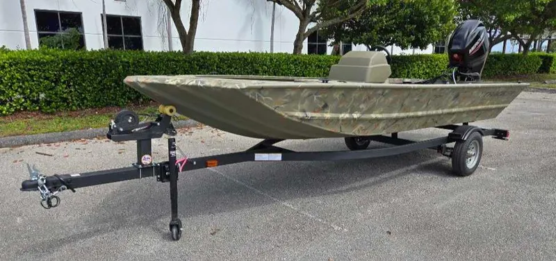 Slide: The Image of 2025 Tracker Grizzly 1648 SC boat on trailer, parked outdoors. - 2