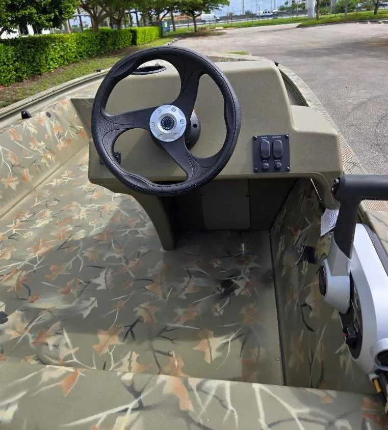 Slide: The Image of 2025 Tracker Grizzly 1648 SC boat interior with camo design and steering wheel. - 5