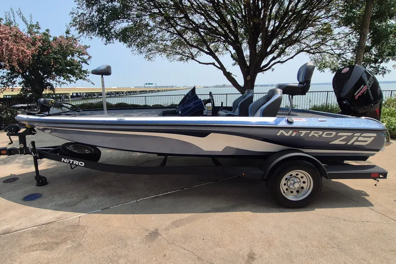 The Image of 2025 Nitro Z19 boat parked by a lakeside, showcasing sleek design and modern features. - 0