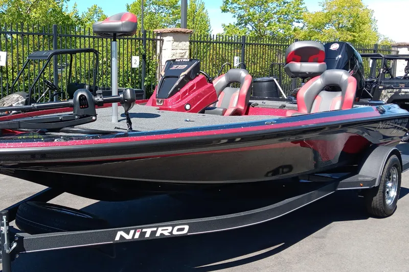 Slide: The Image of 2025 Nitro Z19 boat with sleek design, red and black accents, parked outdoors. - 0