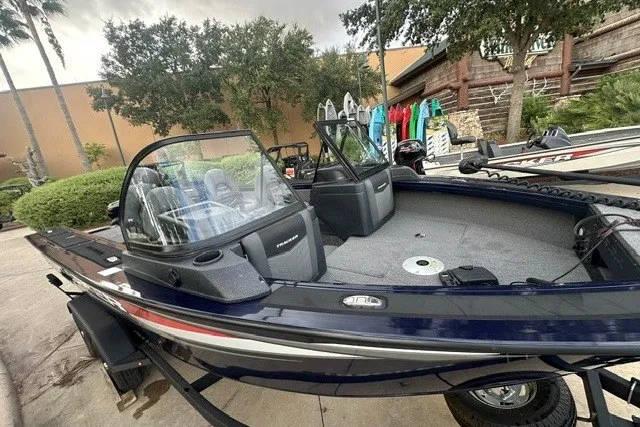 Slide: The Image of 2025 Tracker Targa V-18 WT boat with dual consoles and spacious interior, parked outdoors. - 13