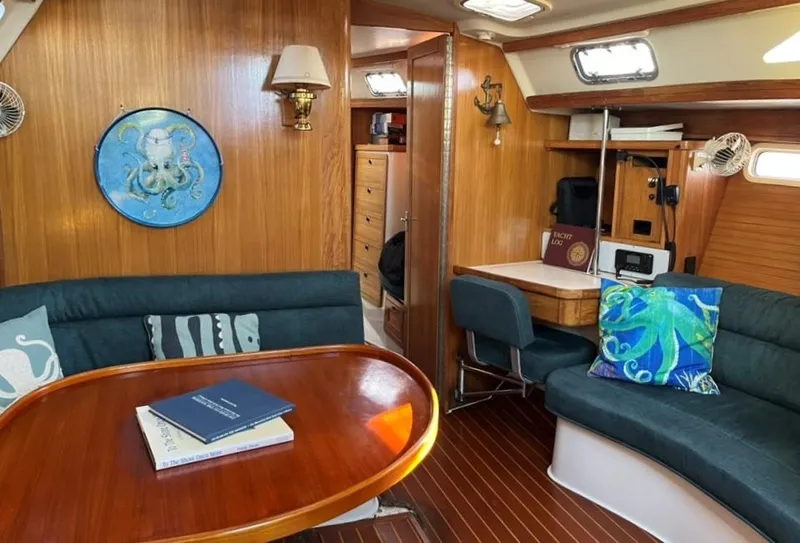 Slide: The Image of Cozy Catalina 42 Mk II 1998 sailboat interior with wooden table and cushioned seating. - 10