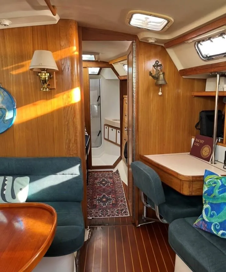 Slide: The Image of Interior of a 1998 Catalina 42 Mk II sailboat with wooden furnishings and cozy seating. - 12