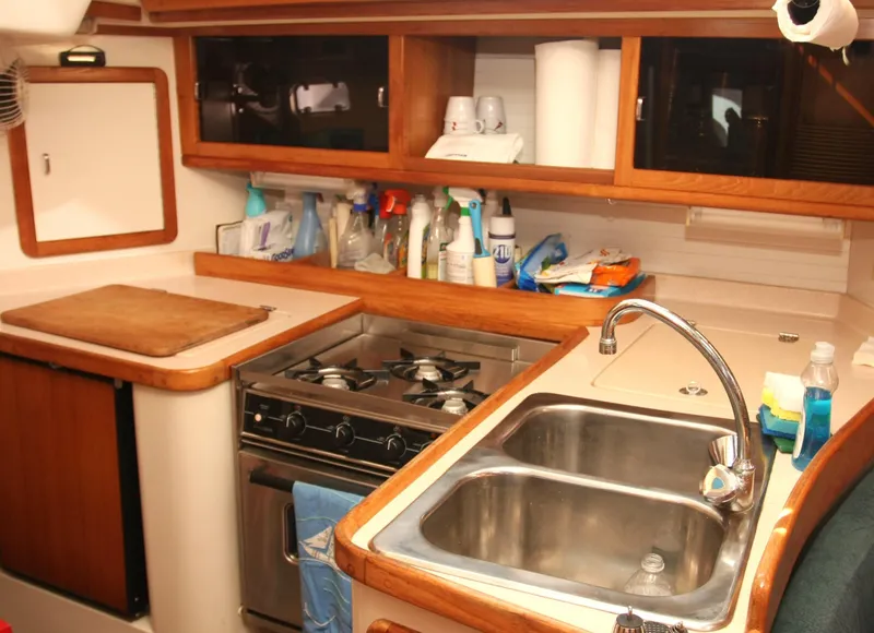 Slide: The Image of Interior of 1998 Catalina 42 Mk II sailboat, featuring a well-equipped kitchen with wooden cabinetry. - 17