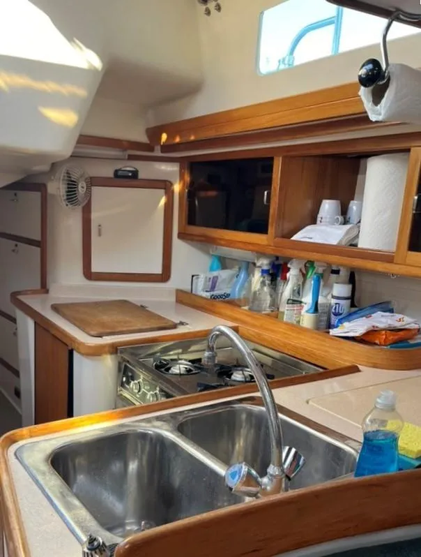 Slide: The Image of 1998 Catalina 42 Mk II yacht kitchen with stove, sink, and wooden cabinetry. - 18