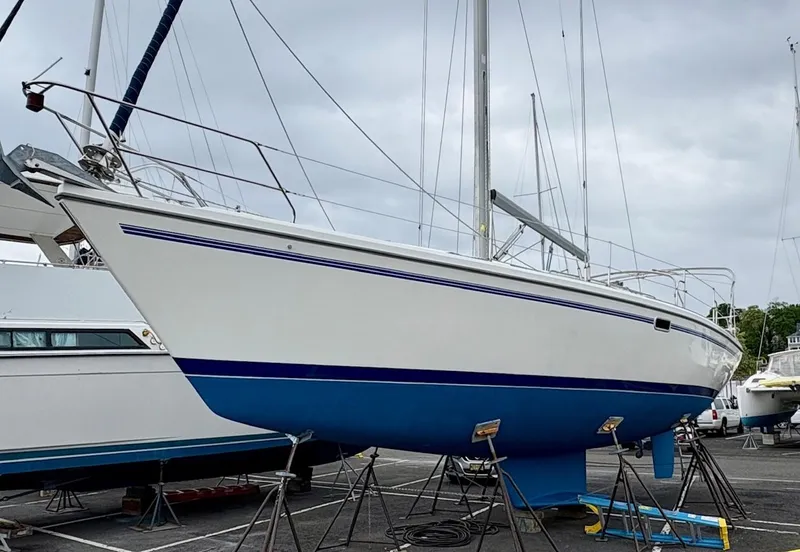 Slide: The Image of 1998 Catalina 42 Mk II sailboat on stands, white hull with blue stripe, overcast sky. - 36