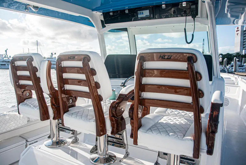 Slide: The Image of Luxury seating on 2022 HCB 53 Sueños boat, featuring elegant wood and white upholstery. - 13