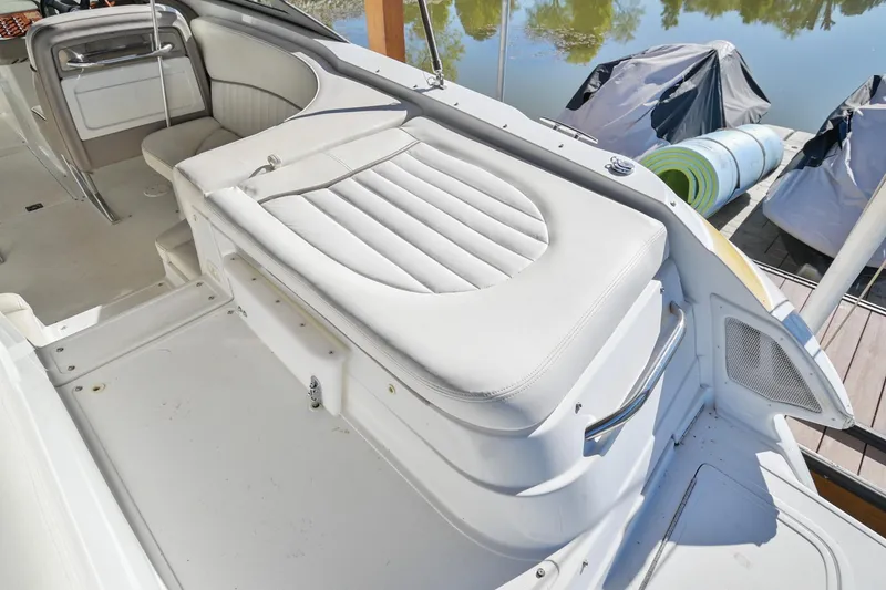 Slide: The Image of 2002 Cobalt 262 boat interior with white leather seating and docked background. - 11