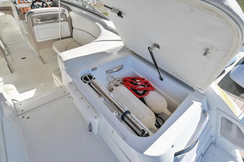 Slide: The Image of Open storage compartment on 2002 Cobalt 262 boat, containing safety equipment and accessories. - 12