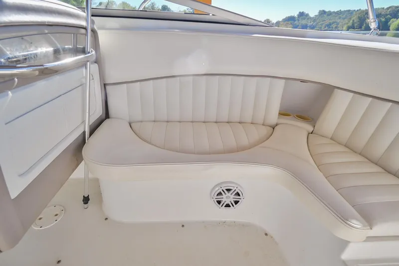 Slide: The Image of 2002 Cobalt 262 boat interior with white cushioned seating and speaker. - 16