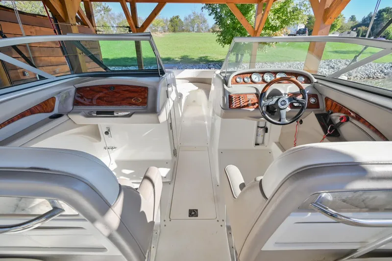 Slide: The Image of Interior of a 2002 Cobalt 262 boat with white seating and wooden dashboard accents. - 19