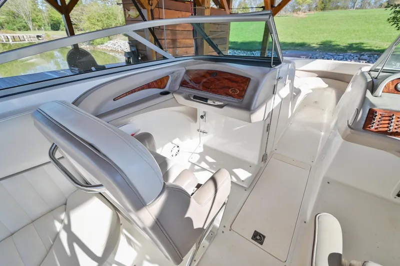 Slide: The Image of 2002 Cobalt 262 boat interior with white seating and wood accents. - 21