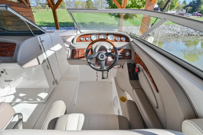 Slide: The Image of Interior of a 2002 Cobalt 262 boat with wood accents and steering wheel. - 25