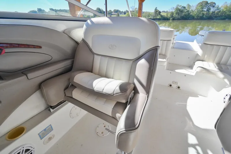 Slide: The Image of 2002 Cobalt 262 boat interior with white leather seating and scenic lake view. - 30