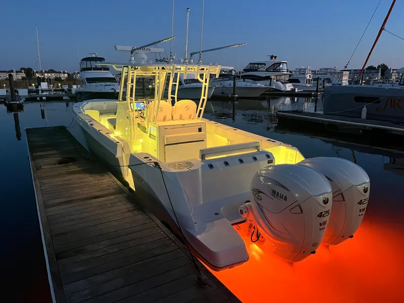 Slide: The Image of Edgewater 340CC 2022 boat with illuminated deck and twin Yamaha engines at marina dock. - 10
